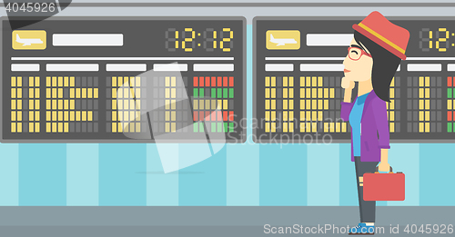 Image of Woman looking at schedule board in the airport.