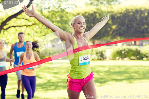 Image of happy young female runner winning on race finish