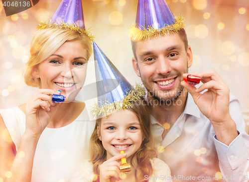 Image of smiling family in blue hats blowing favor horns