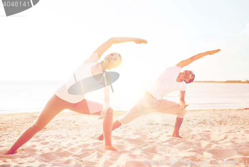 Image of couple making yoga exercises outdoors