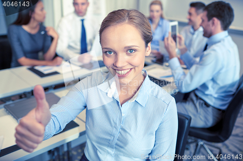 Image of group of smiling businesspeople meeting in office