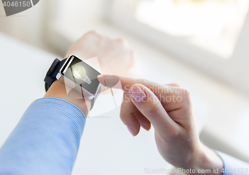 Image of close up of hands with light bulb on smart watch