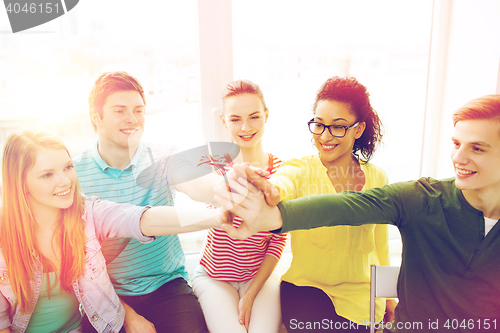 Image of smiling students making high five gesture sitting