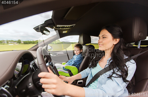 Image of happy woman with little child driving in car