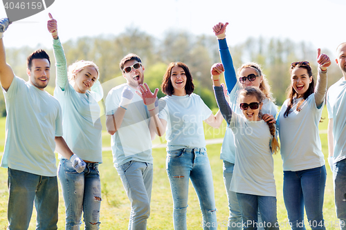 Image of group of volunteers showing thumbs up in park