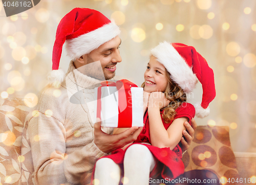Image of smiling father giving daughter gift box