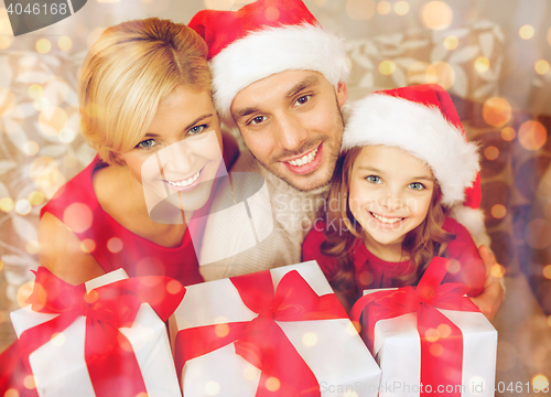 Image of smiling family holding many gift boxes