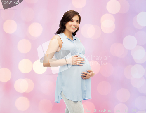 Image of happy pregnant woman touching her big belly