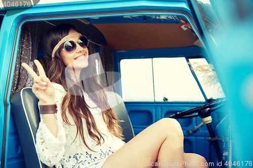 Image of happy hippie woman showing peace in minivan car