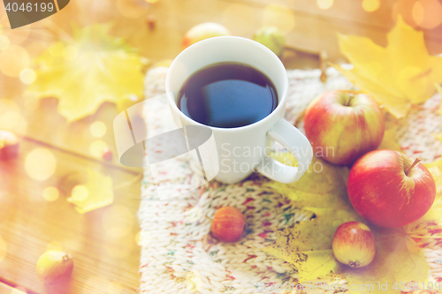 Image of close up of tea cup on table with autumn leaves