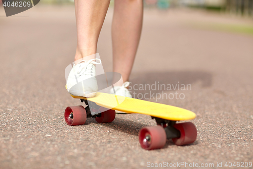 Image of close up of female feet riding short skateboard