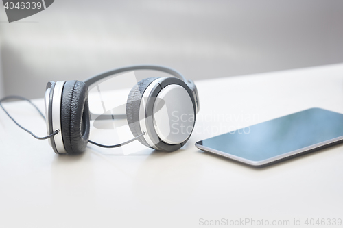 Image of Headphones and tablet computer on a table