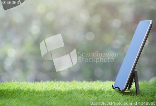 Image of Digital tablet standing on a grass