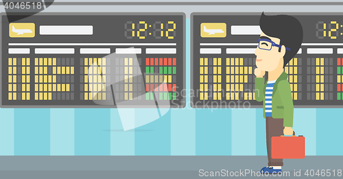 Image of Man looking at departure board in the airport.