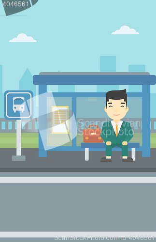 Image of Man waiting for bus at the bus stop.