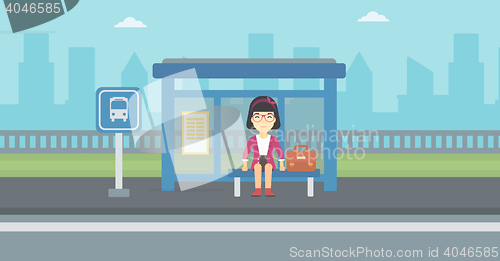 Image of Woman waiting for bus at the bus stop.