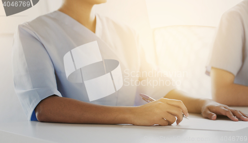 Image of close up of doctor taking notes at hospital