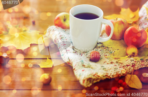 Image of close up of tea cup on table with autumn leaves