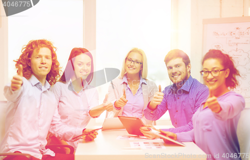 Image of smiling team with table pc and papers working