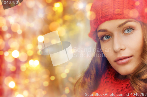 Image of happy woman in hat and scarf over lights