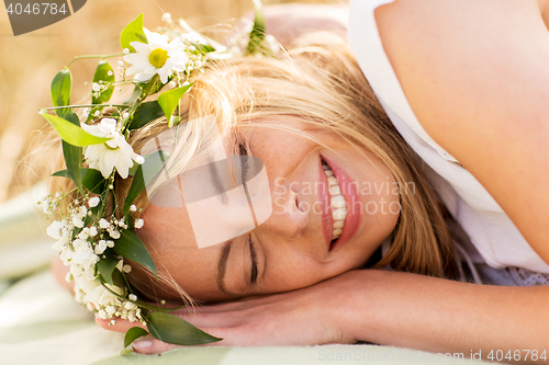 Image of happy woman in wreath of flowers lying