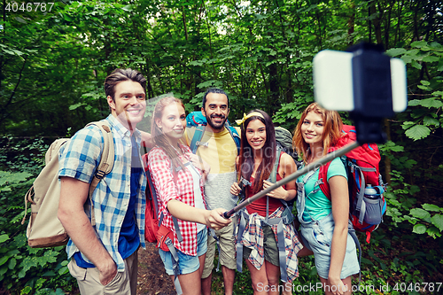 Image of friends with backpack taking selfie by smartphone