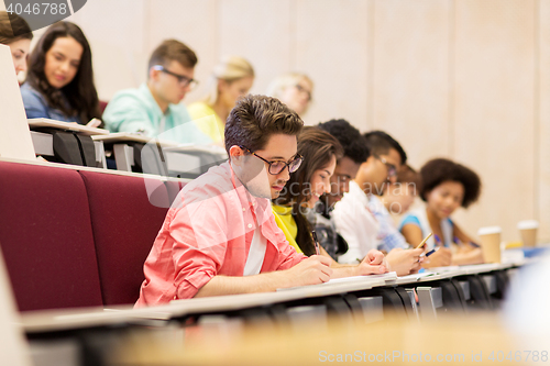 Image of group of students with notebooks in lecture hall