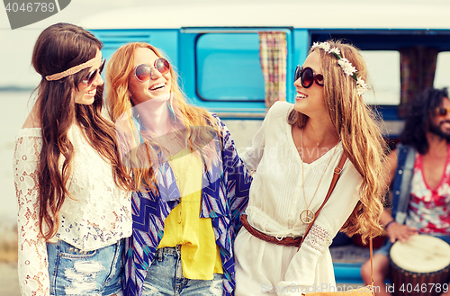 Image of happy hippie friends having fun over minivan car