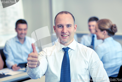 Image of group of smiling businesspeople meeting in office