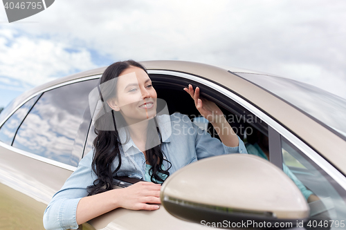 Image of happy young woman driving in car