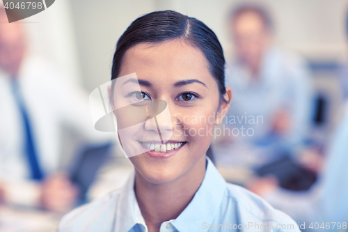 Image of group of smiling businesspeople meeting in office