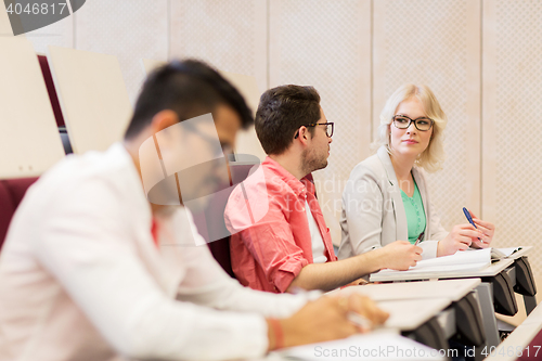 Image of group of students with notebooks in lecture hall