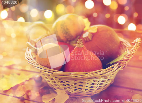 Image of close up of pumpkins in basket on wooden table