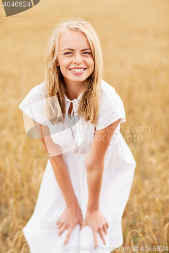 Image of smiling young woman in white dress on cereal field