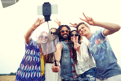 Image of hippie friends with smartphone on selfie stick