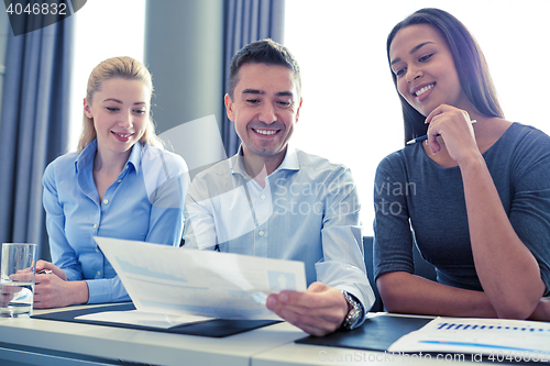 Image of group of smiling businesspeople meeting in office