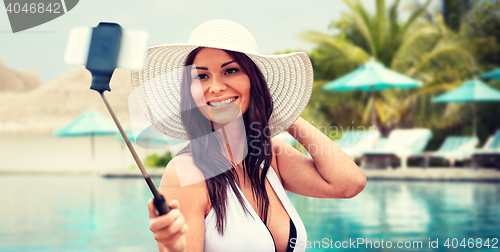 Image of smiling young woman taking selfie with smartphone