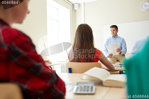 Image of group of students and teacher with papers or tests