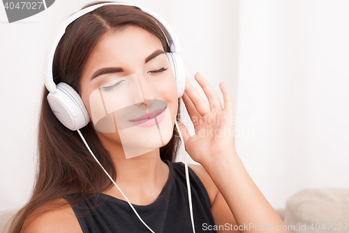 Image of Woman listening music in headphones