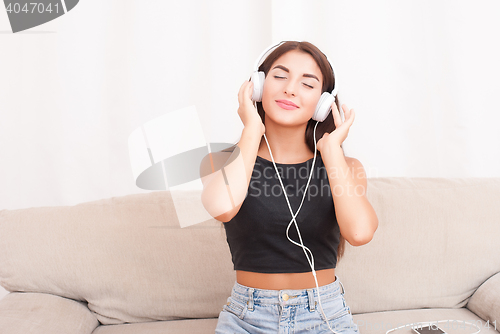 Image of Woman listening music in headphones