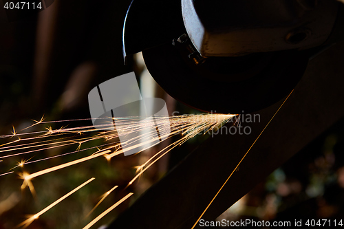 Image of Worker cutting metal with grinder. Sparks while grinding iron