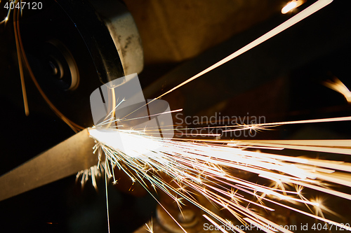 Image of Worker cutting metal with grinder. Sparks while grinding iron