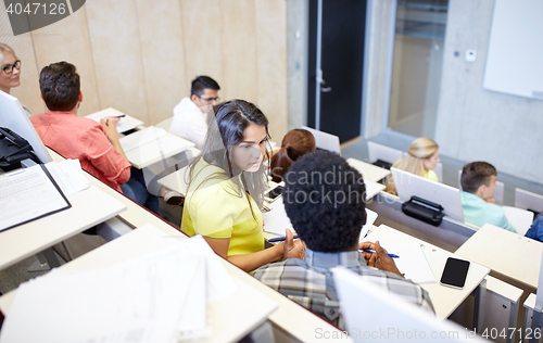 Image of group of students with notebooks at lecture hall