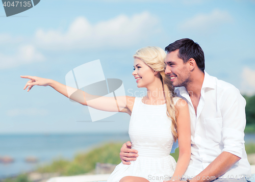 Image of couple sitting at sea side