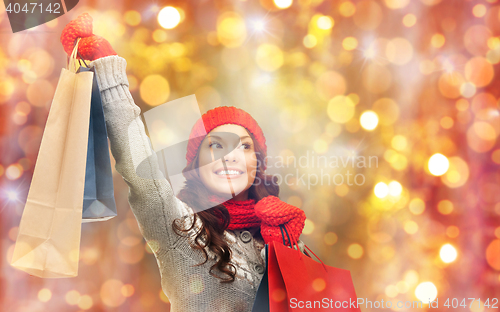 Image of happy woman in winter clothes with shopping bags