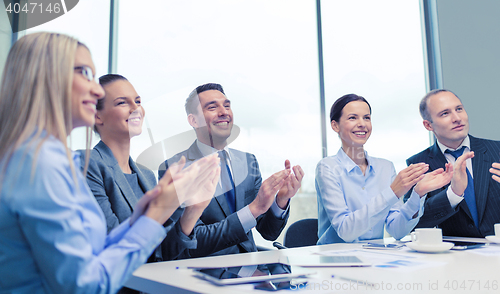 Image of business team with laptop clapping hands