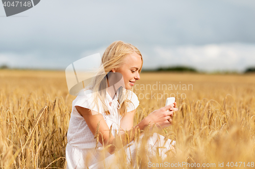 Image of happy woman with smartphone and earphones