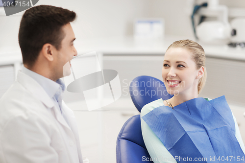 Image of happy male dentist with woman patient at clinic