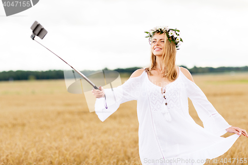 Image of happy young woman taking selfie by smartphone