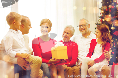 Image of smiling family with gifts at home